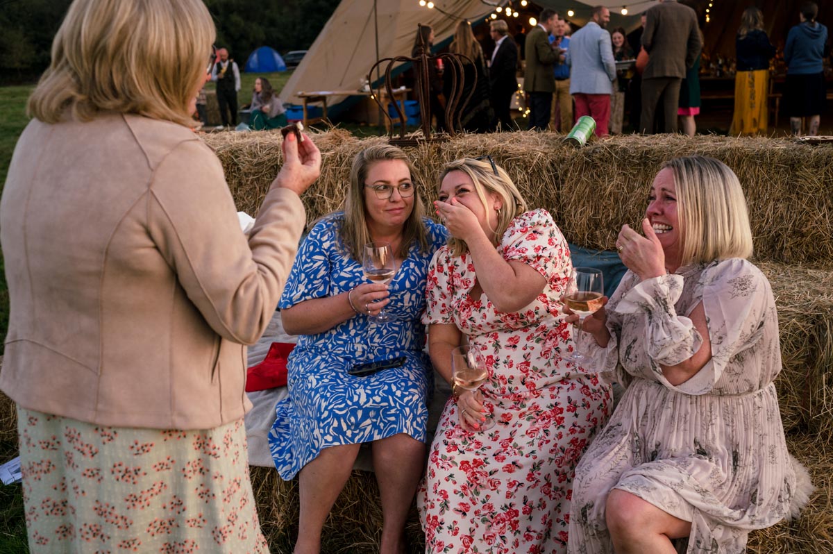 Natural wedding photography. Guests enjoy a laugh.