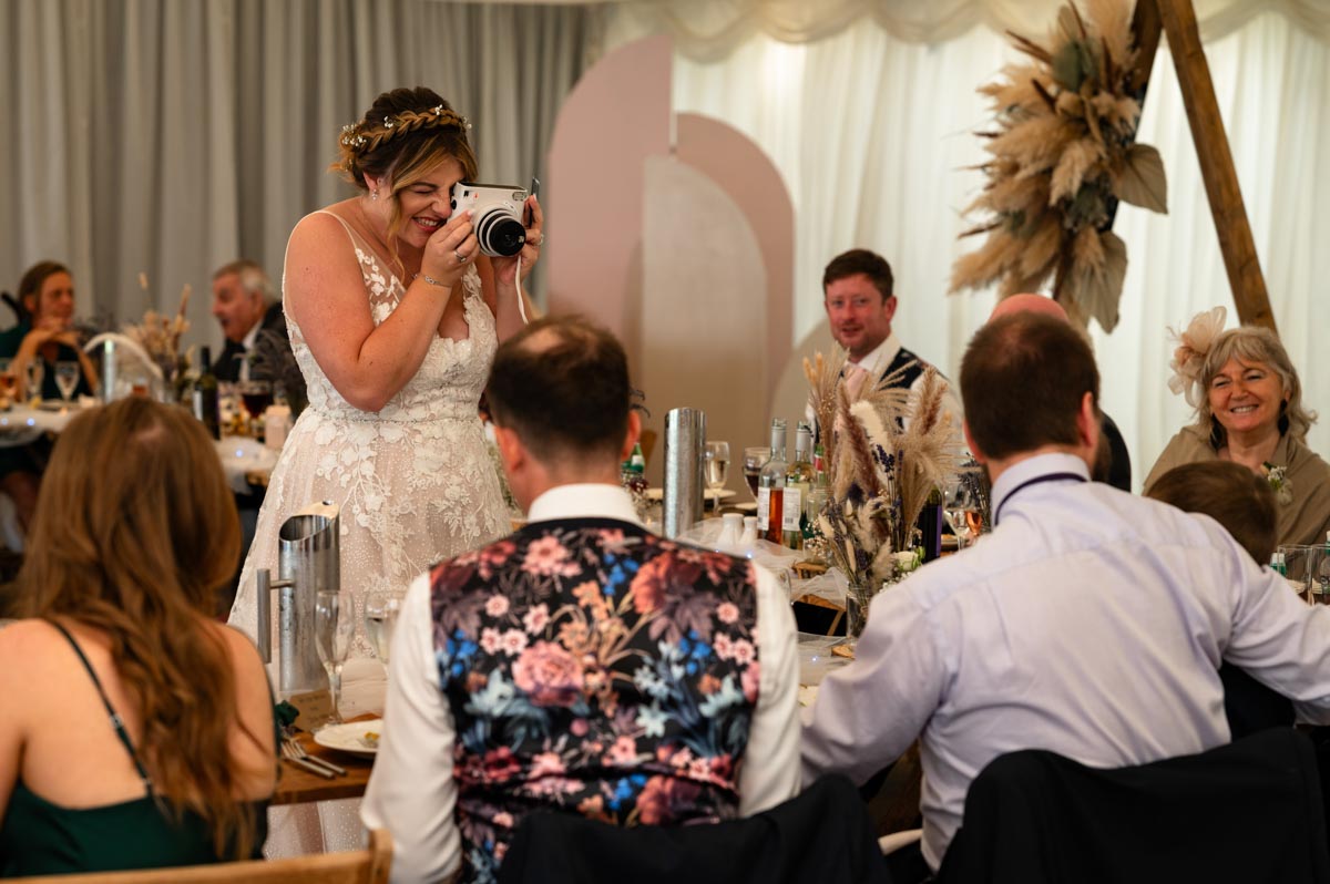 wedding photography at westenhanger castle. bride takes photo