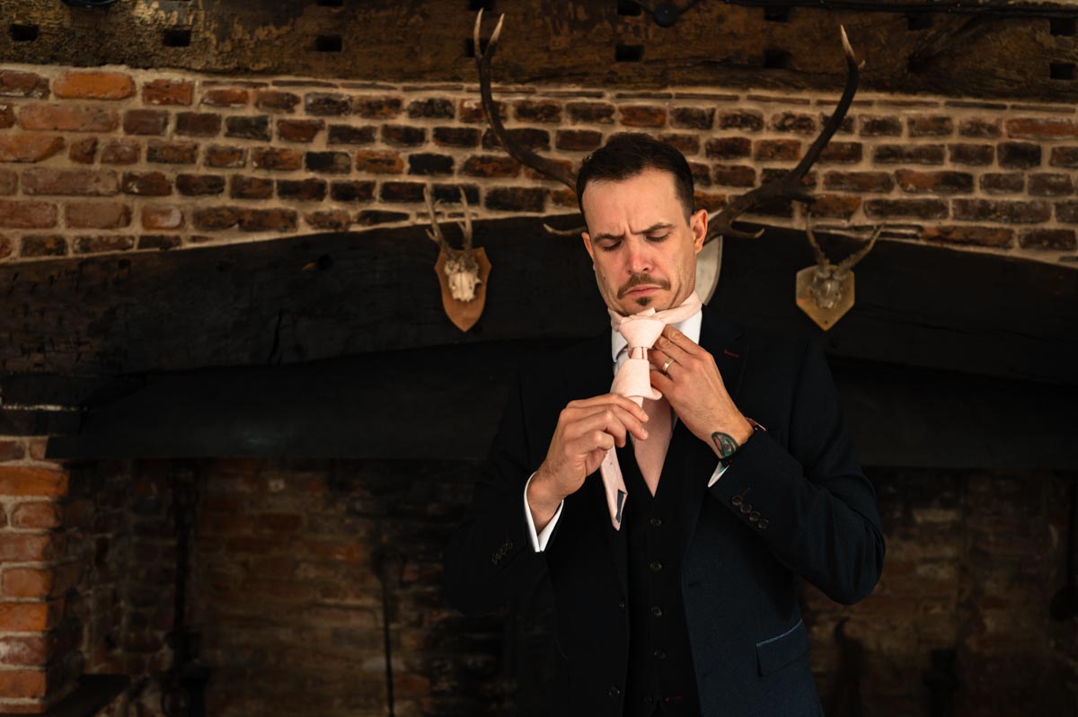 groomsman getting ready at paige and davids westenhanger castle wedding in kent