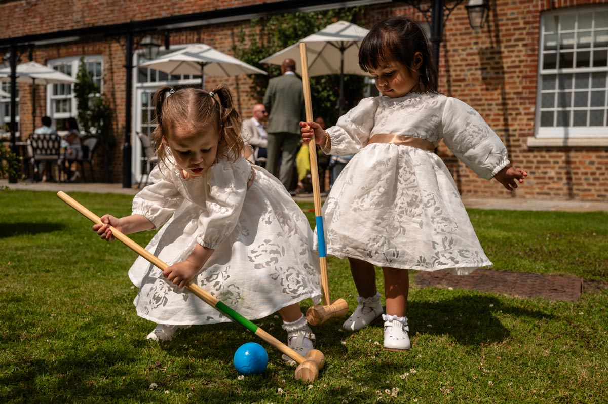 Flower girls play at Elanna and Piyaroes wedding at The secret garden in kent.